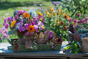 Colorful bouquet from the cottage garden with phlox, marigold, borage and unripe blackberries in a clay pot, pendant with the inscription Phlox