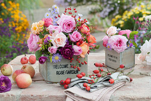 Autumn bouquets made of roses, asters and rose hips in wooden boxes