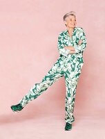 A grey-haired woman wearing subtle a leaf-print trouser suit