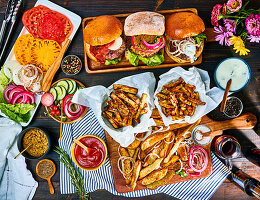 Verschiedene Burger mit Pommes Frites und Zutaten