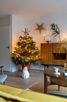 Illuminated Christmas tree in living room decorated in mid-century modern style