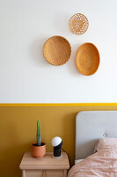 Arrangement of three baskets on wall above yellow-painted dado