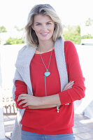 A young blonde woman wearing a red jumper