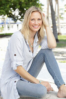 A blonde woman wearing a light-blue striped shirt and jeans