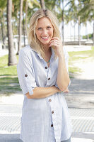 A blonde woman wearing a light-blue striped shirt