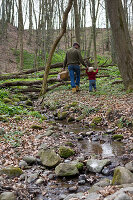 Vater mit Kind im Frühling im Laubwald