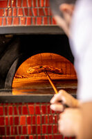 A pizza being baked in a stone oven