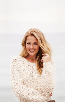 Blonde Frau in hellem Strickpullover