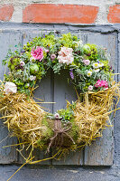 Summer wreath of roses, lady's mantle and straw