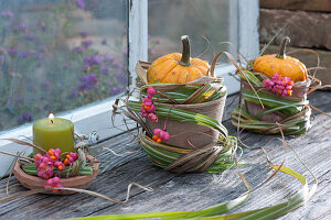 Patisson pumpkins and candle wrapped in grass cuffs and common spindle at the window