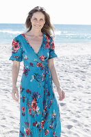 Langhaarige Frau im Sommerkleid am Strand