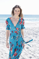 A long-haired woman on the beach wearing a summer dress