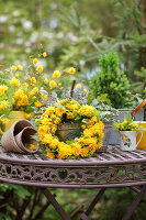 Frühlingsdekoration mit Blütenkranz aus gefüllter Kerrie