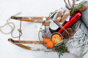 Fully loaded sled with blanket, thermos flask, marshmallow and nut bread