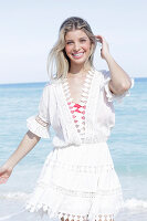 Junge blonde Frau in weißem Sommerkleid mit Stickerei