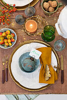 Baubles with verdigris effect and place cards on dining table decorated with Christmas