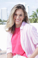 Junge blonde Frau in pink Shirt und gestreiftem Hemd