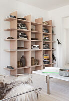 View over coffee table with marble top to shelf in a bright living room