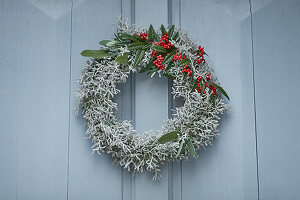 Wreath of santolina and cotoneaster with red berries on door