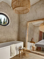 Large mirror and bathtub in the bathroom with neutral colored walls