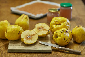 Quince jelly preparation with quince fruits and two pots on wood table