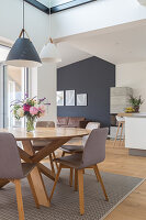 Runder Esstisch mit grauen Stühlen in offenem Wohnraum