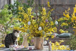 Easter bouquet made of flowering branches of forsythia, decorated with Easter eggs