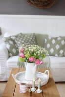 Bouquet of ranunculus, viburnum and feverfew in a coffee pot