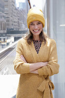 Joyful woman in yellow cardigan and hat