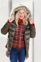 Blonde Frau in Winterjacke mit Fellkapuze, darunter rot Jacke mit Hahnentrittmuster