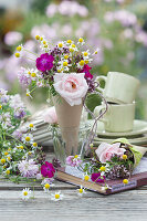 Sommerliche Tischdeko: kleine Sträuße mit Rosen, Kamille, Vexiernelken, Kronwicke und Dost in Spitztüten