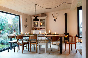 Long dining table with chairs, Christmas decorations and antlers on the wall