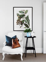 Weißer Sessel mit Kissen und Tasche neben Stele mit Zimmerpflanze