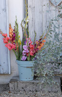 Bouquet of gladioli in enamelled bucket, eucalyptus