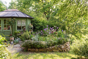 Gartenhäuschen und Blumenbeet mit Umrandung