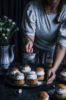 Semla (Swedish cream puffs) being dusted with icing sugar