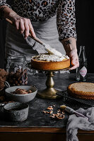 Walnut cake being spread with cream