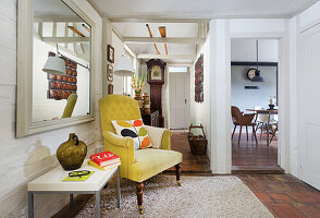 Vintage living room with yellow armchair and large wall mirror