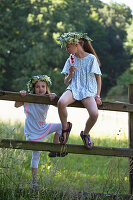 Children wearing elderflower wreaths eating ice pops