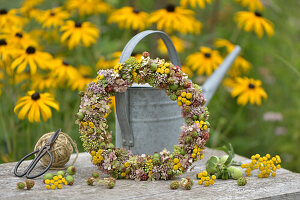 Late summer wreath made of fat hen, tansy, blackberries, rose hips and hydrangeas on a wire ring