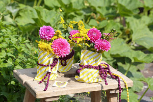 Colourful autumn bouquet of dahlias and goldenrod in paper bags