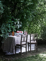 Gedeckter Tisch mit oppluneter Tischdecke im Garten