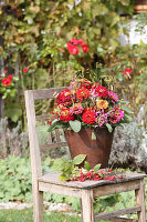 Bouquet of zinnias with sage, wild fennel and grasses in a rusty iron pot