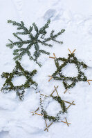 Sterne aus Nadelzweigen im Schnee