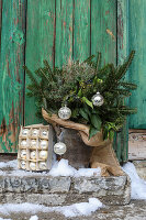 Winterstrauß mit Weihnachtskugeln und Juteband im Blecheimer