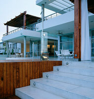 Zeitgenössische Hausfassade mit Stufen, die zum Poolbereich und zur Terrasse führen