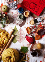 Knitting needles and paintpots with book on tabletop in Isle of Wight, UK