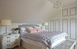 Spacious bedroom in the attic with built-in wardrobes and light wood panelling