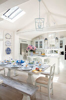 Country-style dining table with blue and white crockery and kitchen island