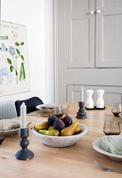 Set dining table with fruit bowl and candlesticks, school map